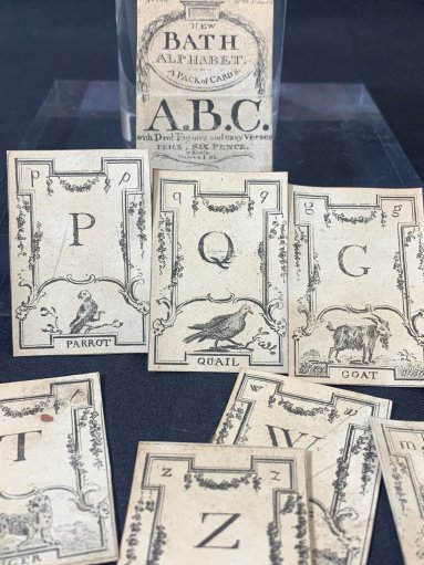 This bundle of cards was intended to be educational as well as fun. A child also hand-embroidered a small bag for what was probably a precious game.